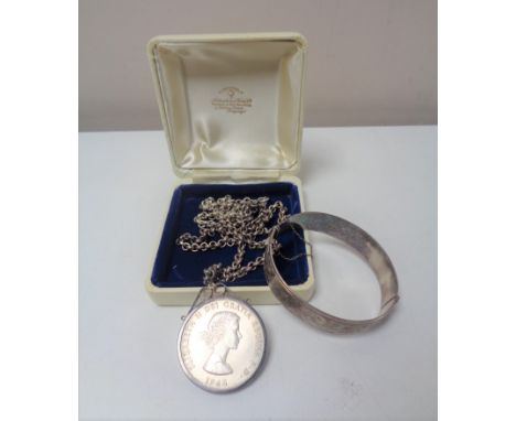 A silver bangle and a Churchill crown in mount on silver chain 