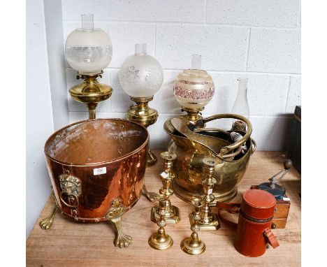A copper and brass log bucket with lion masque handles, two brass coal helmets, four brass oil lamps, two pairs of brass ejec
