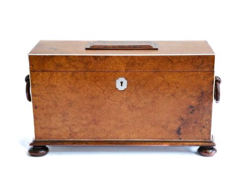 A 19th-century burr walnut tea caddy with rosewood and ivory inlay and turned handles, with a fitted interior of two compartm