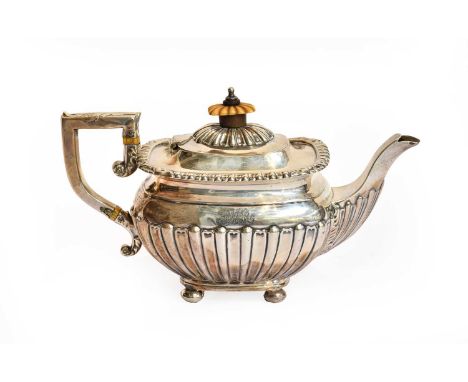 An Edward VII Silver Teapot, by William M Hayes, Birmingham, 1901, oblong and on four bun feet, the lower body part fluted, w