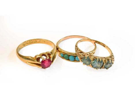 An 18 carat gold synthetic ruby ring, finger size M; a 9 carat gold blue zircon three stone ring, finger size K; and a turquo