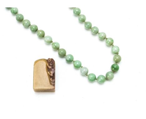 A string of green jadeite jade knotted circular beads, clasp broken, 38cm, 9.5mm diameter together with a Chinese soapstone s