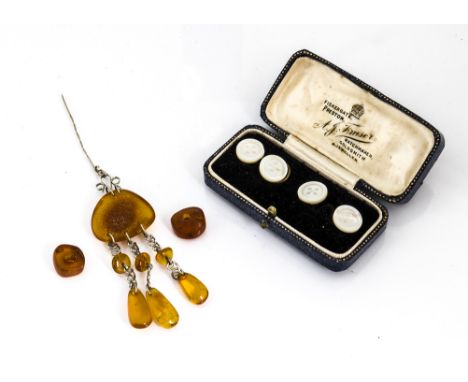 An amber and white metal pin brooch, the pin supporting stylised fleur de lys with boulder amber pebble and three drops, toge