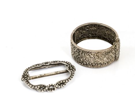 A 19th Century silver belt buckle, of knot design, London 1899 together with an Edwardian white metal hinged bangle decorated