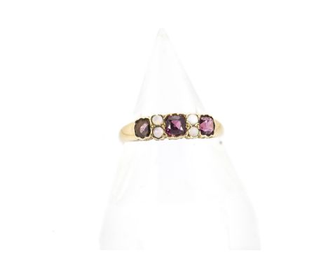 An early 20th Century 18ct gold garnet and opal dress ring, the three cushion cut garnets alternately set with pairs of circu