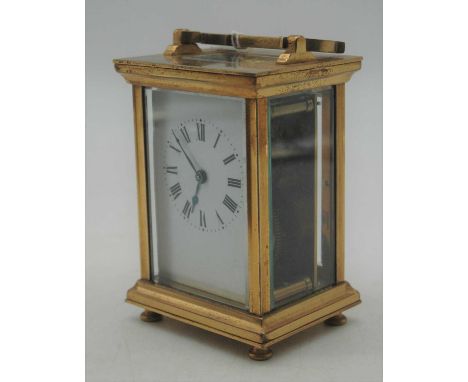 A 20th century lacquered brass cased carriage clock, having an enamelled dial with Roman numerals, visible platform lever esc