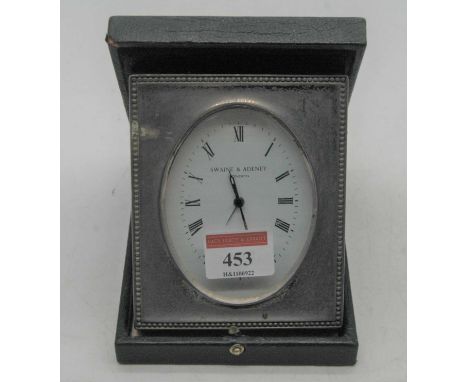 An early 20th century silver clad travel clock, the oval enamelled dial with Roman numerals and signed Swayne &amp; Adeney of