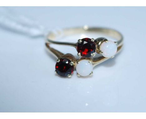 A modern yellow metal, garnet and opal set dress ring, stamped 14k, 2.6g, size L