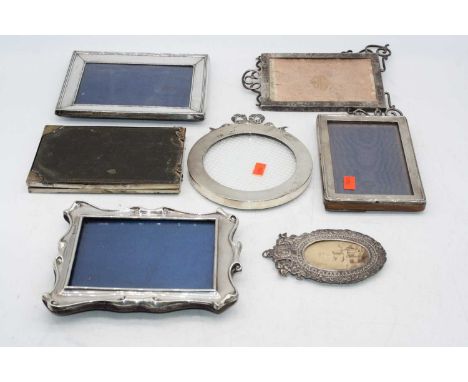 A collection of assorted silver clad easel photograph frames, to include circular example surmounted by a tied bow, folding d