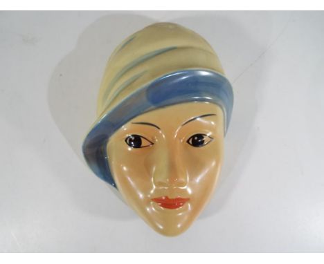 A Crown Devon art deco ceramic wall plaque depicting a lady's head signed to the rear by the artist Dorothy Ann. Estimate £20