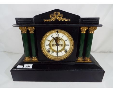An American cast-iron cased mantel clock, the black painted case flanked by four green Corinthian columns, two-piece white en