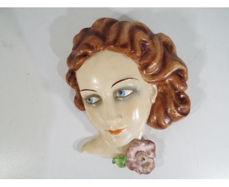 A Goebel art deco wall plaque depicting a lady with a flower. Estimate £50 - £70