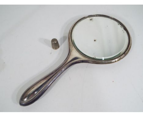 A George V silver hallmarked hand mirror Birmingham assay 1912 with a silver hallmarked thimble Chester assay 1897 makers mar