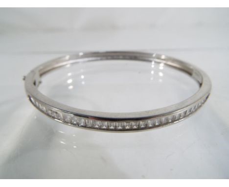 A silver bangle set with clear stones 