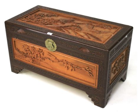 A contemporary Asian wooden trunk. Each side inset with carved panels depicting birds and foliage, the borders carved with fl