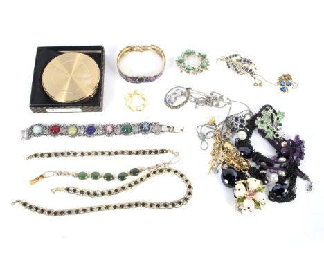 An assortment of costume jewellery. Including brooches, necklaces, an enamel bangle etc