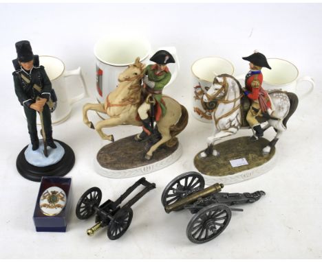 An assortment of military ceramics and collectables. Including a selection of mugs, three ceramic figures, two miniature meta