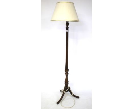 A 20th century floor lamp. The wooden structure with ribbed details, raised on three splayed supports, cream shade, H141cm (e