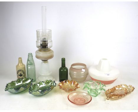 An assortment of glassware. Including a Retro lamp shade decorated with orange lines, an oil lamp, two antique bottles, carni