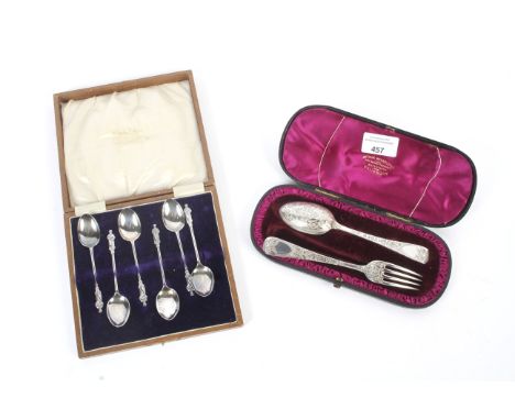 A cased silver spoon and fork set in velvet lined presentation case. The spoon and fork highly decorated Hallmarked London an