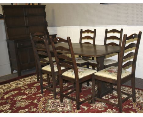 An Ercol dining room suite comprising an open dress with two drawers above two cupboards. The dining table L152cm x D76cm x H