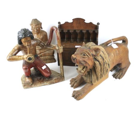 Three carved wooden sculptures and a miniature wall cabinet. Comprising a seated Buddha, H36cm, a lion L52cm and a pipe smoke