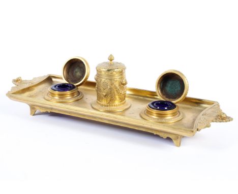 A French Empire style gilt metal inkstand, 19th century, with a central integral cylindrical pot and cover cast with palmette