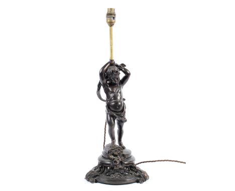 A Victorian style bronzed table lamp, cast as a putti supporting a single light, on a waisted pierced base cast with flowers 