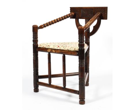 A late 19th century oak bobbin turned corner chair, the back carved with diamond pattern and foliate cartouche, with reeded a