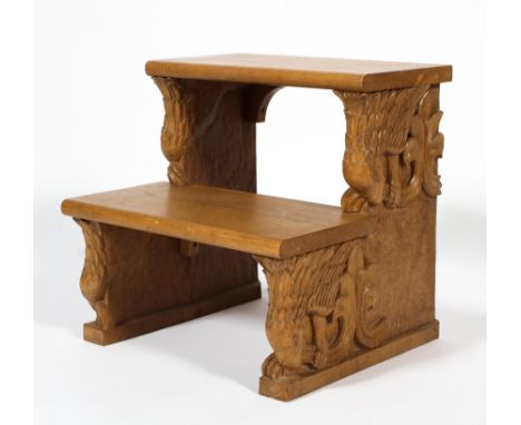 A set of contemporary carved oak steps, two tiered, the sides carved with a bird of prey perched and biting reeded trefoil fo