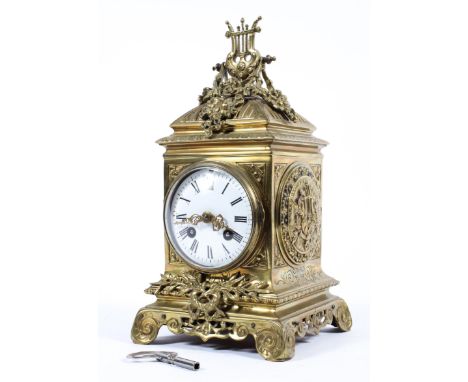 A French cast gilt brass mantle clock. White enamel face with Roman numeral markers. Eight day movement striking on a coiled 