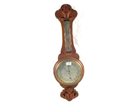 A carved Oak aneroid barometer (split glass)