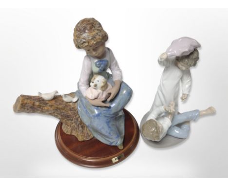 A Nao figure of two boys pillow fighting, together with a further figure on plinth of a girl with puppy.