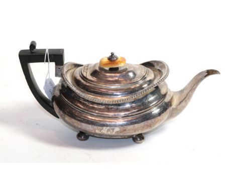 A George III silver teapot, by William Burwash, London 1819, compressed oblong and on four bun feet, with later ebonised wood