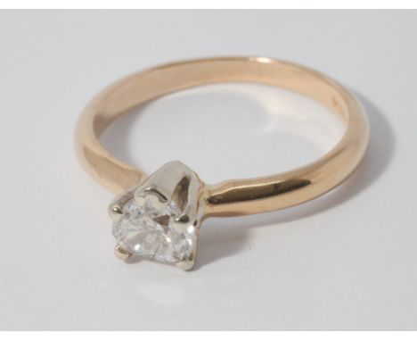 Modern heart shaped diamond solitaire engagement ring, claw set on a yellow 14 karat gold shank. Diamond is approximately 0.4