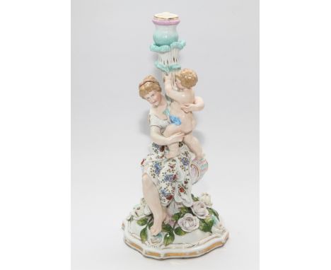Large continental porcelain candlestick, modelled as a classically clad female holding a putto aloft. Blue cross sword mark t