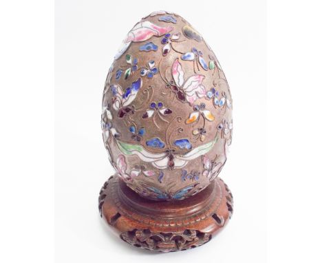 Oriental, poly-chrome enamel, white metal egg on carved hardwood stand. Standing approximately 16 cm tall  Dented and some en