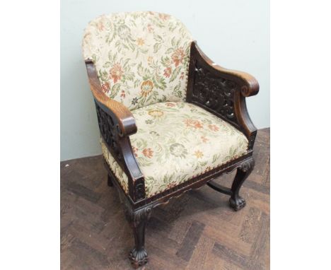 Early 20th century carved oak, tub shaped elbow chair; standing on paw feet with cross stretcher base and tapestry upholstere