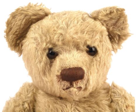 A Steiff  style teddy bear, early 20th century, with glass eyes, hand stitched snout, jointed limbs and leather pads.  Height