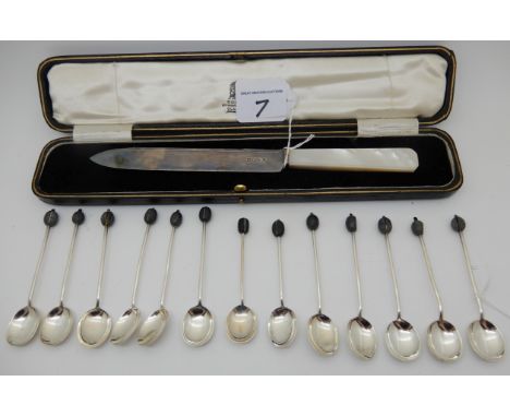 A lot comprising thirteen silver coffee bean spoons, assorted marks and a cased silver and mother of pearl handled cake knife