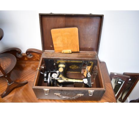 A vintage Singer sewing machine, in faux crocodile skin case