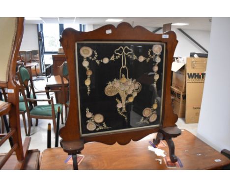 A Victorian mahogany firescreen having embroidered three dimensional panel