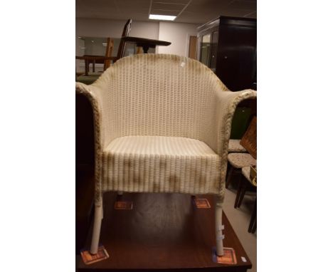 A vintage woven-wicker armchair, in the Lloyd Loom style, white painted with gold painted highlights.