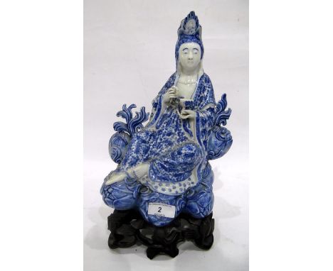 Chinese porcelain blue and white figure of a guanyin on a pierced wooden lotus leaf base, impressed seal mark, modelled recli