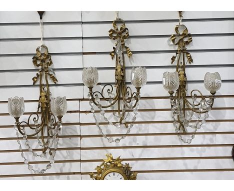 Three gilt metal and glass double-branch wall light brackets with ribbon and foliate decoration, button swags, each scroll wi