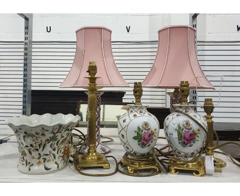 A pair of ceramic table lamps, on brass coloured metal bases painted with roses and gilt decoration, another pair pillar form