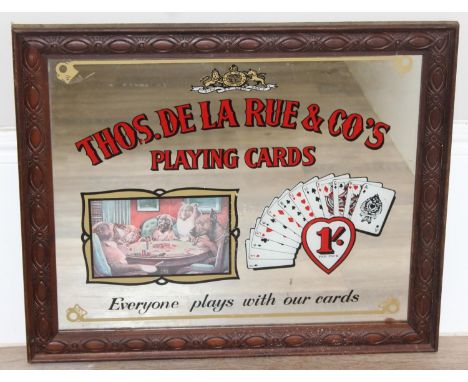 A vintage Thomas De La Rue &amp; Co Playing Cards advertising mirror with decorative oak frame, 62cm x 51cm