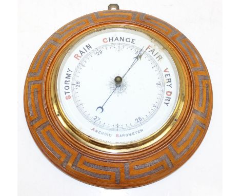A vintage aneroid wall barometer in round light oak case, the case carved with a Greek Key pattern, early 20th century, 33cm 