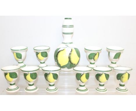 A vintage pottery lemonade set decorated with hand painted lemons, a carafe and 10 glasses, made in Cyprus, the carafe 25cm t