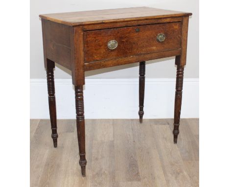A 19th century oak side table or console table with deep single drawer and circular brass handles, standing on turned oak leg